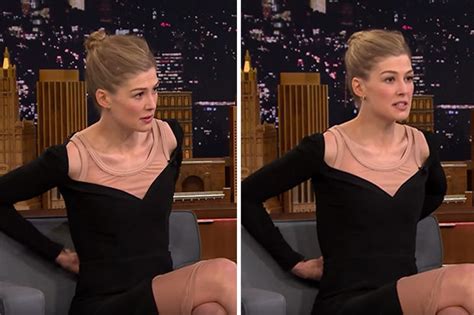 Rosamund Pike risks wardrobe malfunction as she。